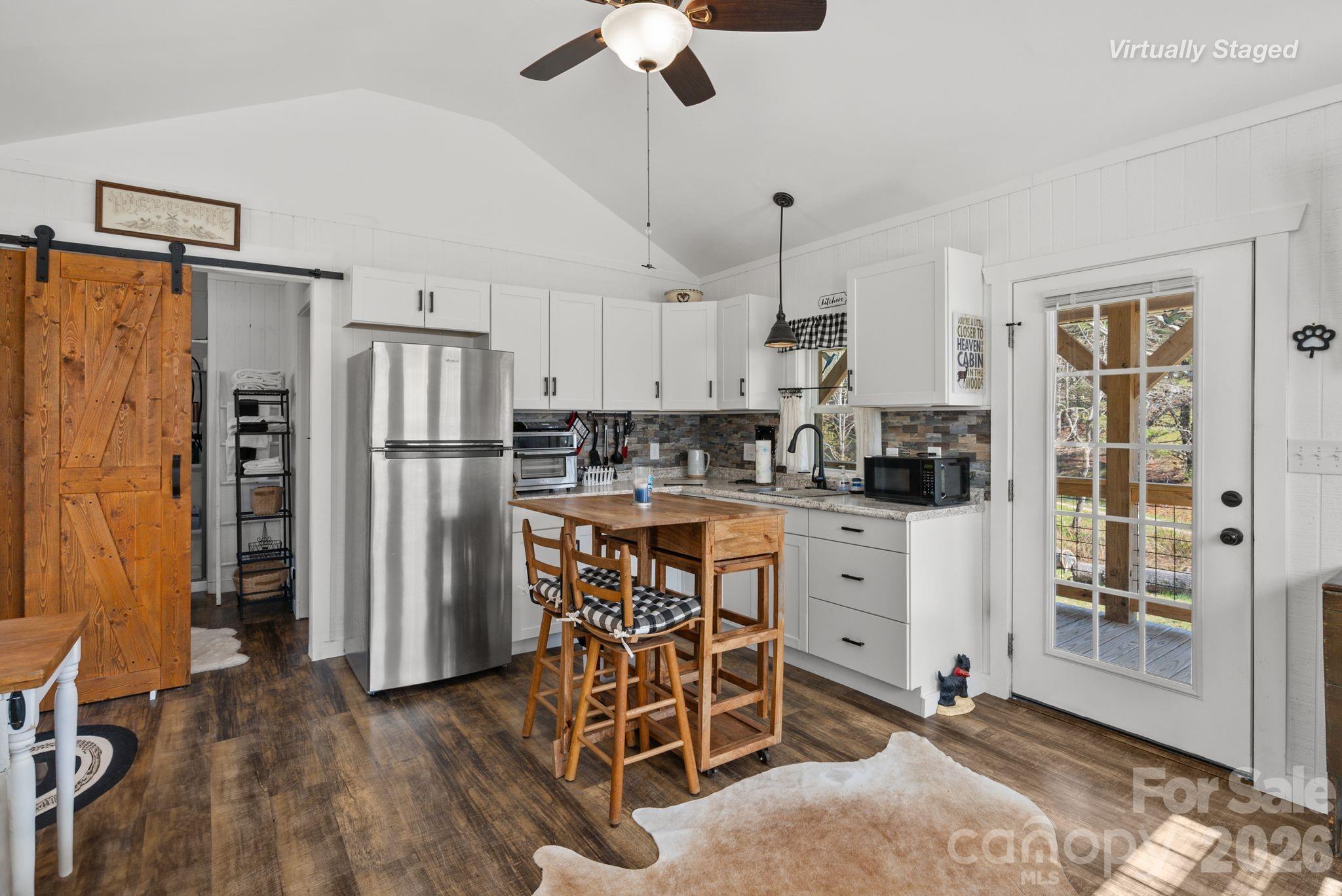 54 South Kimiko Lane Balsam Grove, NC 28708 - Photo 8 of 46 a kitchen with stainless steel appliances a refrigerator a stove a sink dishwasher and white cabinets with wooden floor