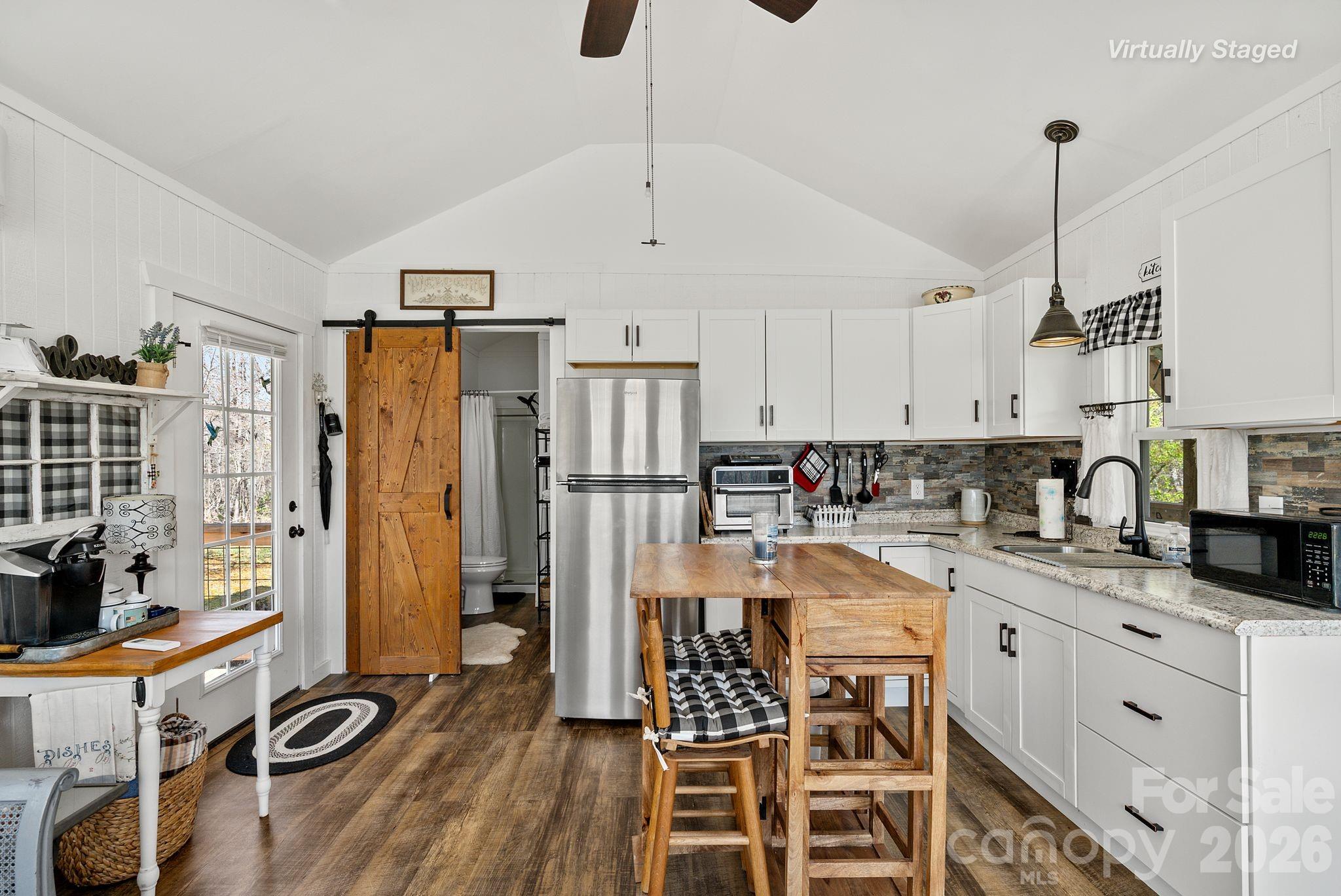 54 South Kimiko Lane Balsam Grove, NC 28708 - Photo 9 of 46 a kitchen with stainless steel appliances kitchen island granite countertop a stove a refrigerator and wooden floors