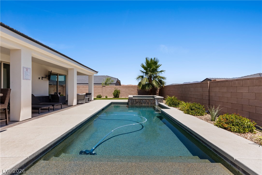 1436 Manassas Ridge Mesquite, NV 89027 - Photo 64 of 77 A tranquil desert oasis boasts a sparkling in-ground pool with an integrated spa, perfect for relaxation.
