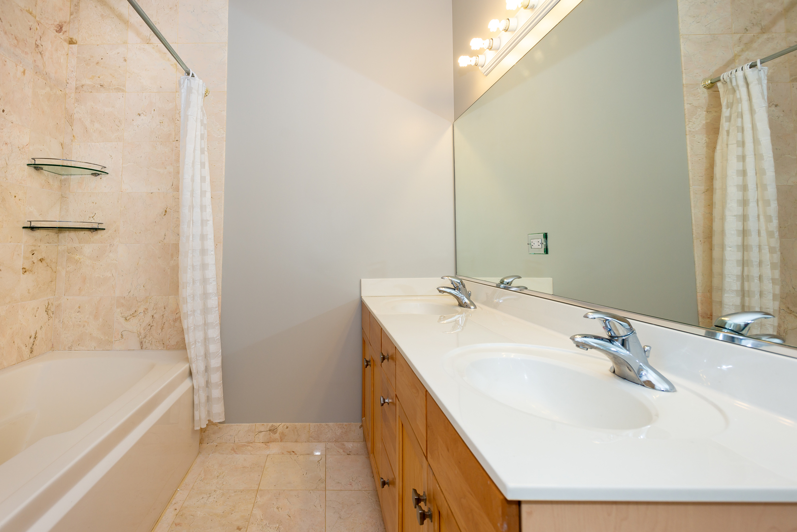 1101 South State Street, Unit 1804 Chicago, IL 60605 - Photo 14 of 29 a bathroom with a double vanity sink and a bathtub