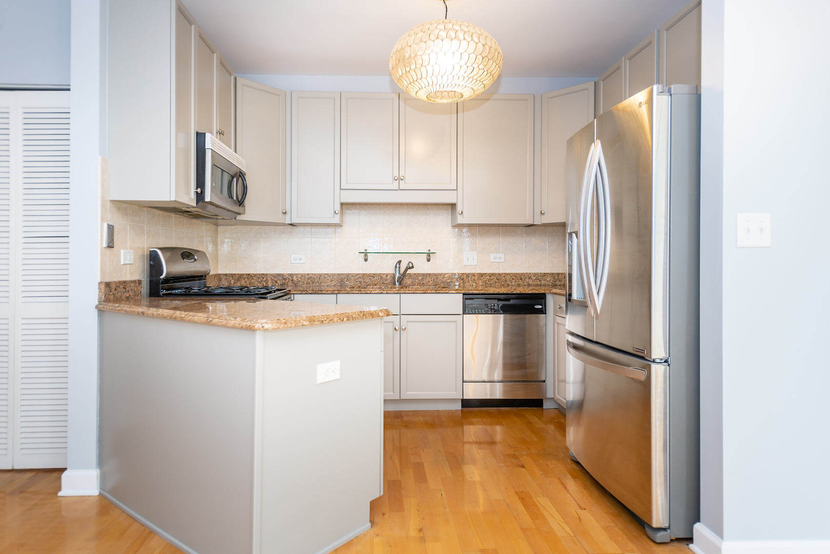 1101 South State Street, Unit 1804 Chicago, IL 60605 - Photo 7 of 29 a kitchen with cabinets and stainless steel appliances