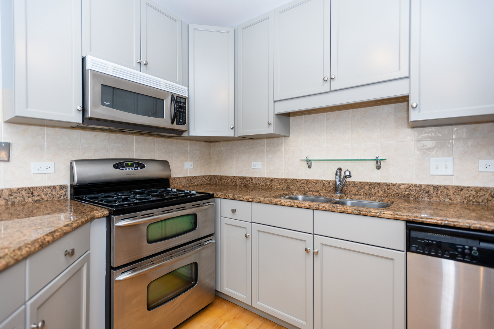 1101 South State Street, Unit 1804 Chicago, IL 60605 - Photo 10 of 29 a kitchen with granite countertop white cabinets and appliances