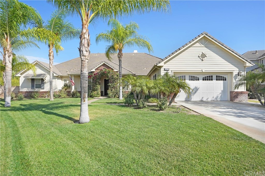 a view of a house with a yard and palm trees