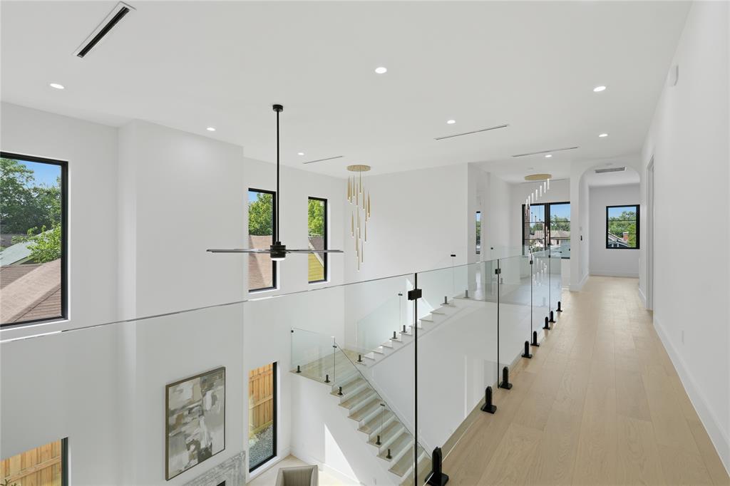 6038 Prospect Avenue Dallas, TX 75206 - Photo 33 of 40 Bright upper-level hallway featuring a glass railing system and light wood-finish flooring