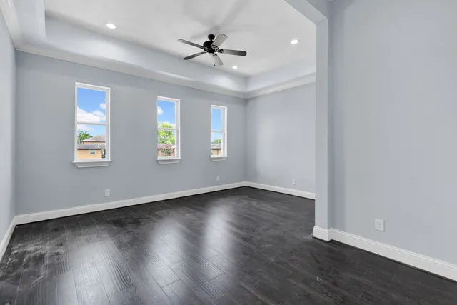 a view of an empty room with a window and wooden floor
