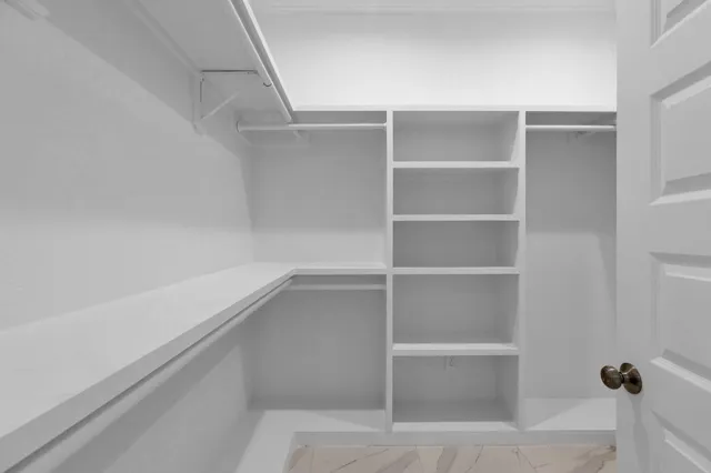 a view of walk in closet with empty racks