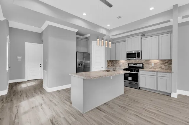 a kitchen with white cabinets and stainless steel appliances