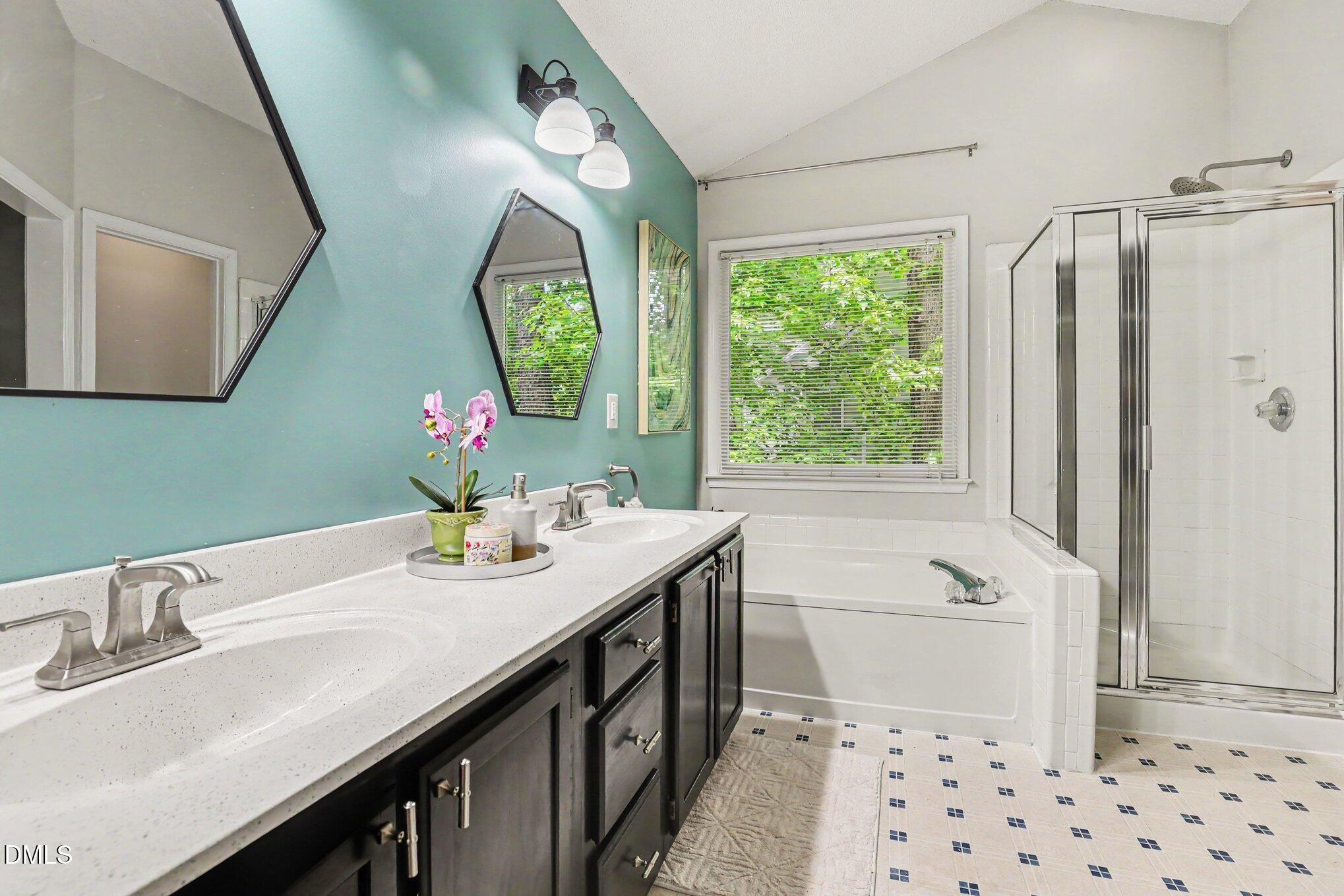5468 Ingate Way Raleigh, NC 27613 - Photo 20 of 24 a bathroom with a sink a mirror and a bathtub