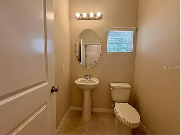 a bathroom with a toilet a sink and a mirror