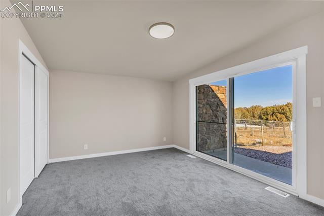 5835 Verde Road Pueblo, CO 81004 - Photo 17 of 50 Unfurnished bedroom with carpet floors, a closet, and access to exterior