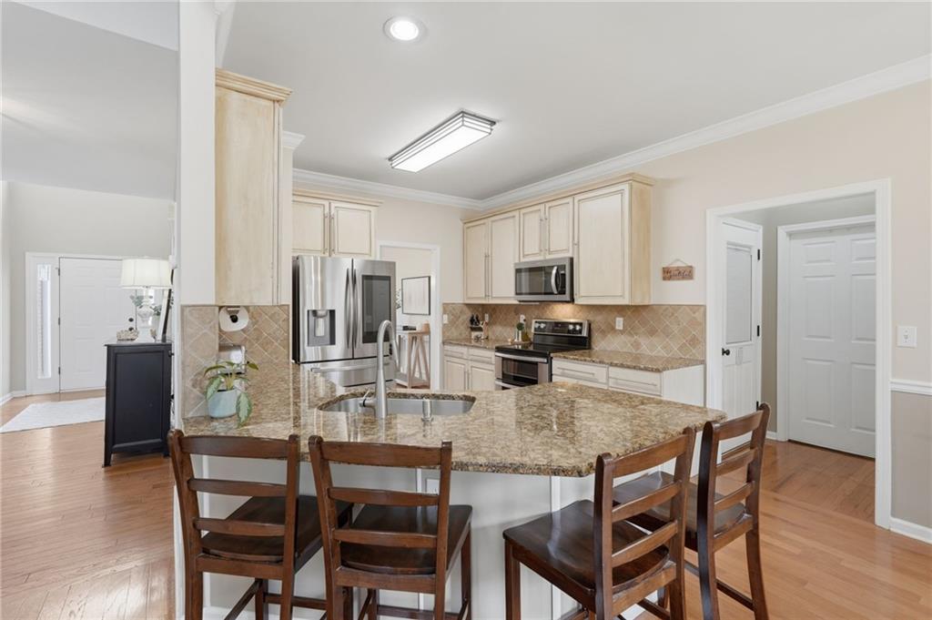 60 Gilbert Circle Northeast Suwanee, GA 30024 - Photo 11 of 47 a kitchen with stainless steel appliances granite countertop a dining table chairs refrigerator and microwave