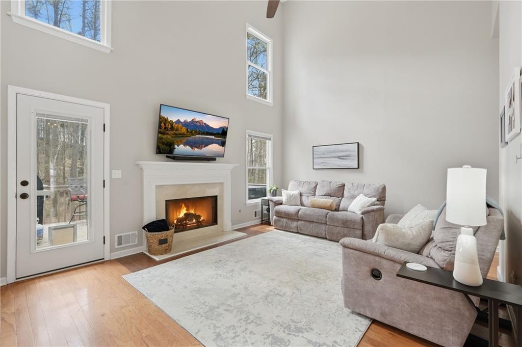 60 Gilbert Circle Northeast Suwanee, GA 30024 - Photo 7 of 47 a living room with furniture a fireplace and a flat screen tv