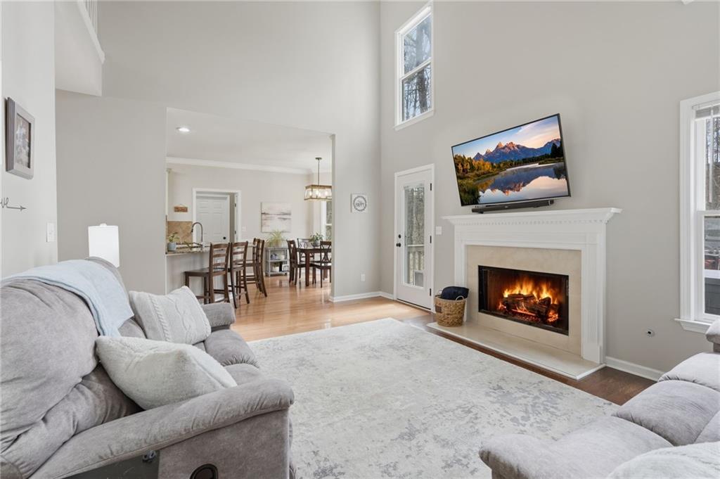 60 Gilbert Circle Northeast Suwanee, GA 30024 - Photo 8 of 47 a living room with furniture a fireplace and a flat screen tv