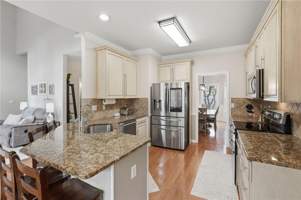 60 Gilbert Circle Northeast Suwanee, GA 30024 - Photo 9 of 47 a kitchen with stainless steel appliances granite countertop a sink refrigerator and cabinets