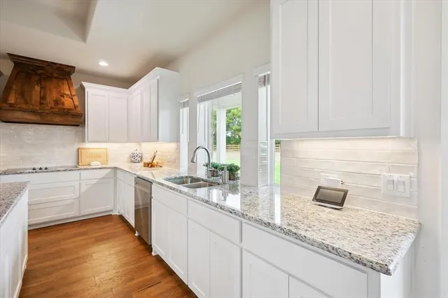 a kitchen with granite countertop white cabinets and stainless steel appliances