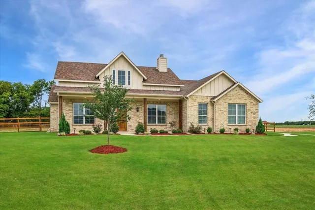 a view of a house with a big yard and large trees