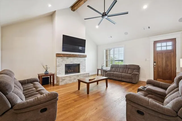 a living room with furniture a flat screen tv and a fireplace