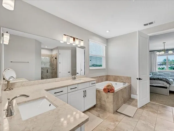 a bathroom with a tub sink and mirror