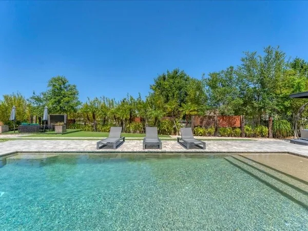 a view of a swimming pool with lounge chairs in patio