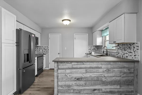 a kitchen with granite countertop a refrigerator and a sink