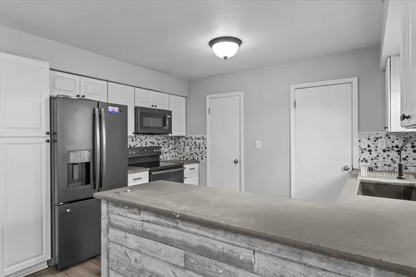 a kitchen with stainless steel appliances granite countertop a refrigerator and a stove top oven