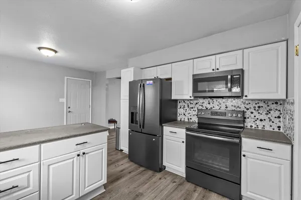 a kitchen with white cabinets stainless steel appliances and sink