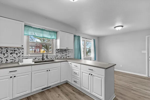 a kitchen with white cabinets and sink