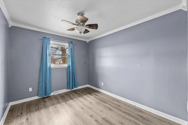 a view of empty room with wooden floor