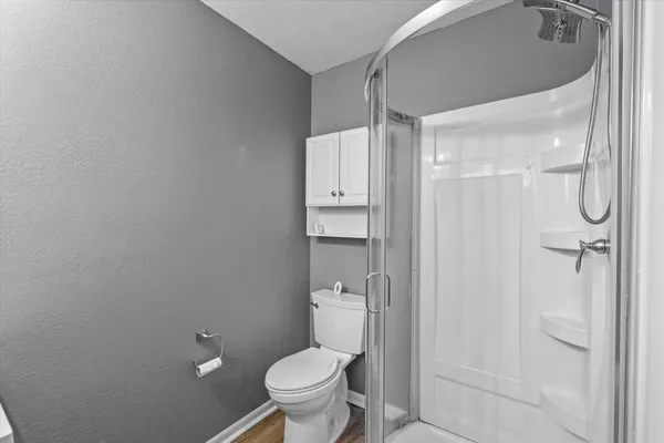 a bathroom with a granite countertop toilet and a shower