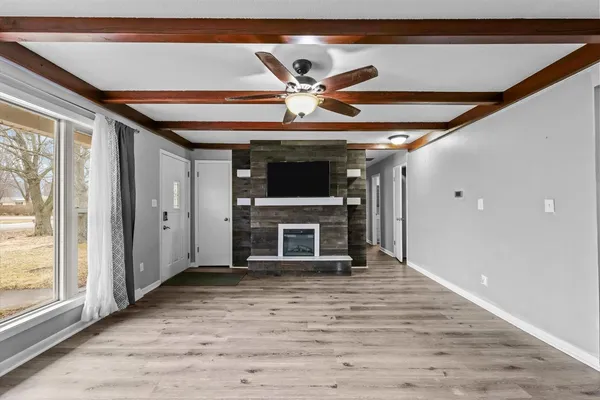 a view of an empty room with a fireplace and a window