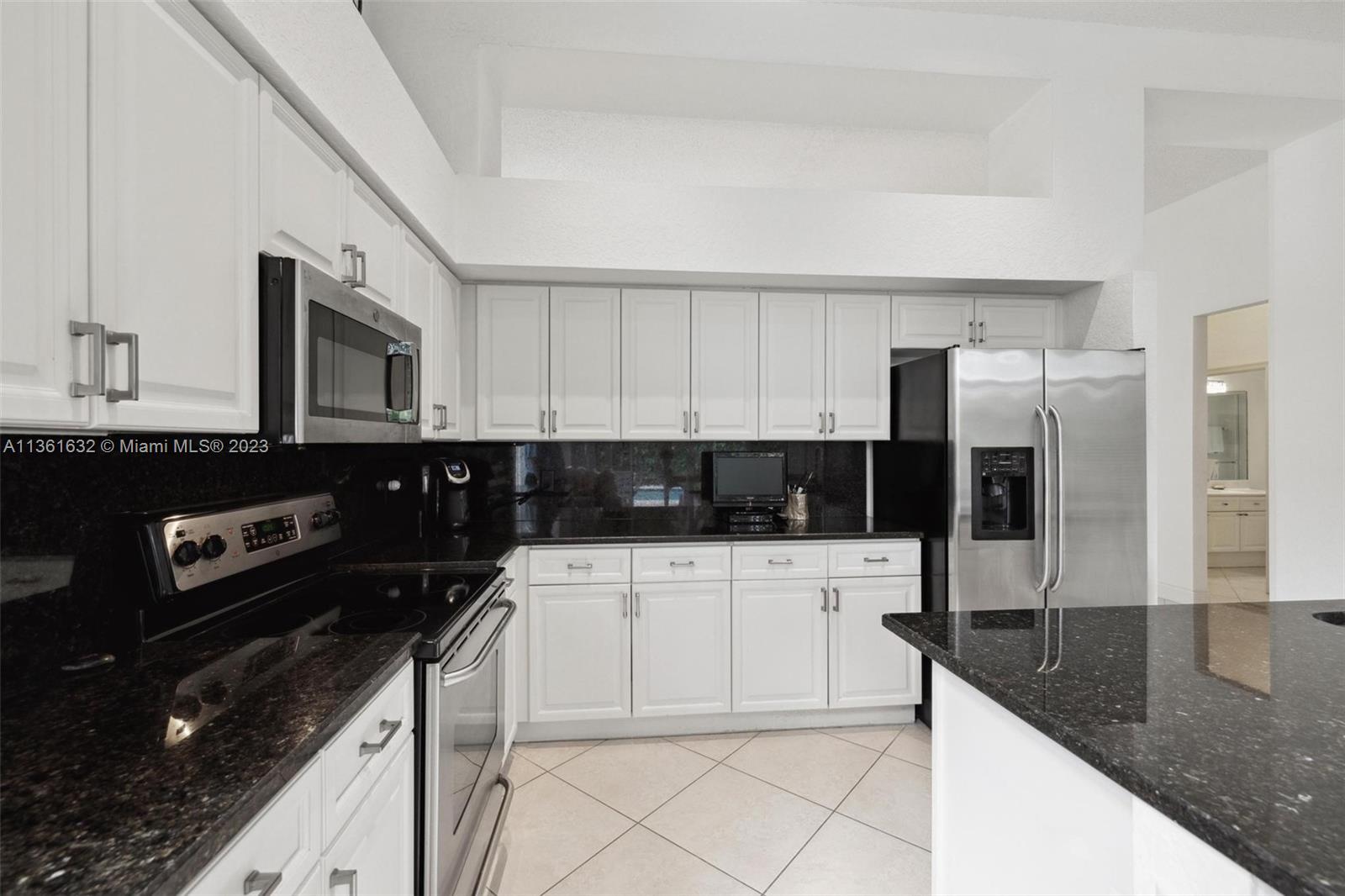 6666 Northwest 23rd Terrace Boca Raton, FL 33496 - Photo 11 of 38 a kitchen with stainless steel appliances a sink a stove and cabinets