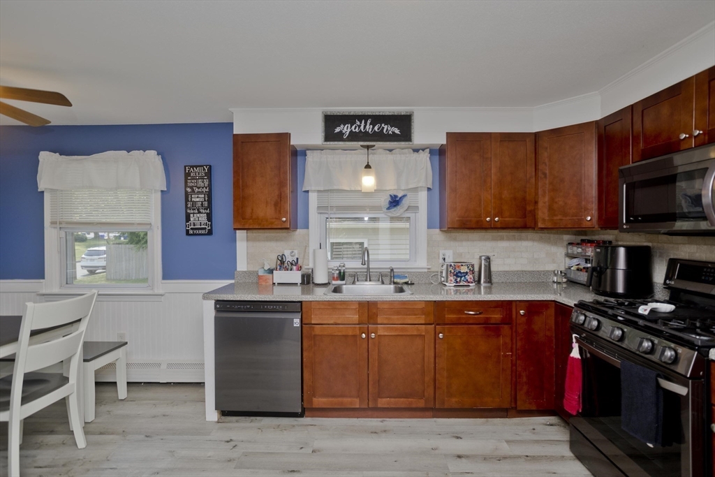 20 Maura Street Springfield, MA 01104 - Photo 8 of 41 a kitchen with stainless steel appliances granite countertop a stove a sink dishwasher and a microwave oven with wooden cabinets