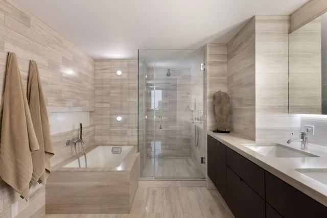 a bathroom with a granite countertop sink a toilet a mirror and shower