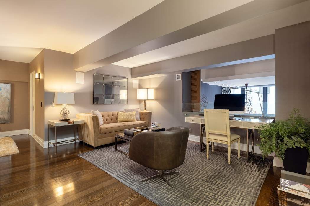 421 Hudson Street, Unit 420 Manhattan, NY 10014 - Photo 7 of 15 a living room with furniture wooden floor and a flat screen tv