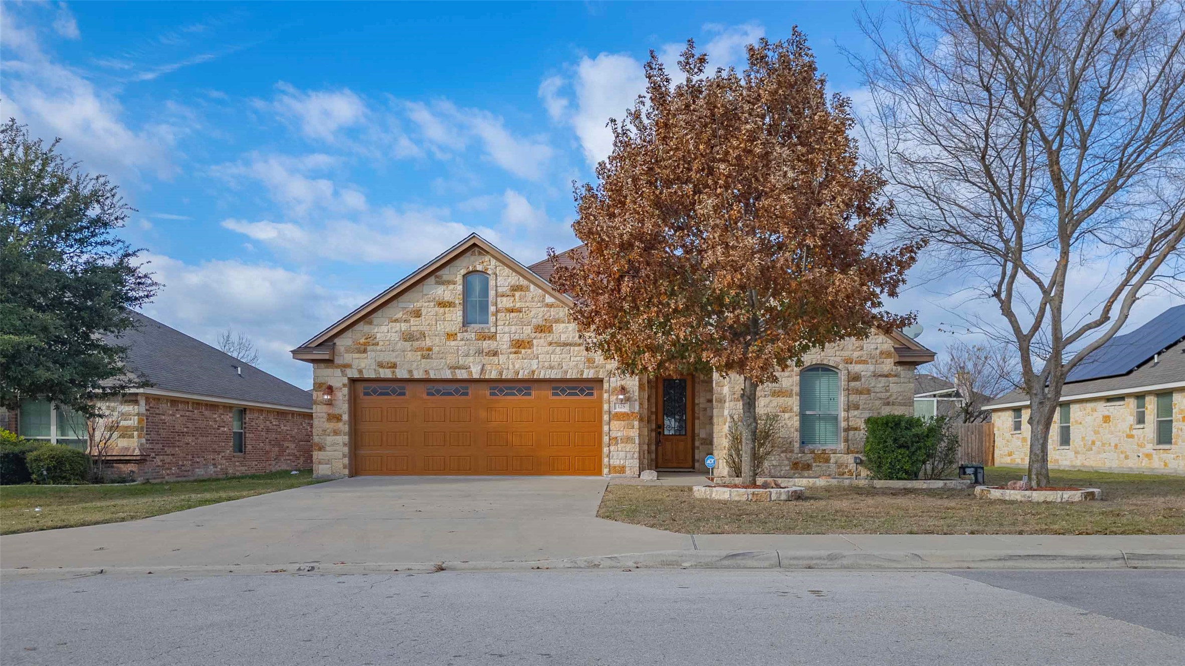 125 Walter Way Jarrell, TX 76537 - Photo 1 of 1 View of front facade featuring stone siding, concrete driveway, and an attached garage