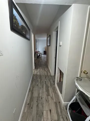 a view of a hallway with wooden floor and staircase