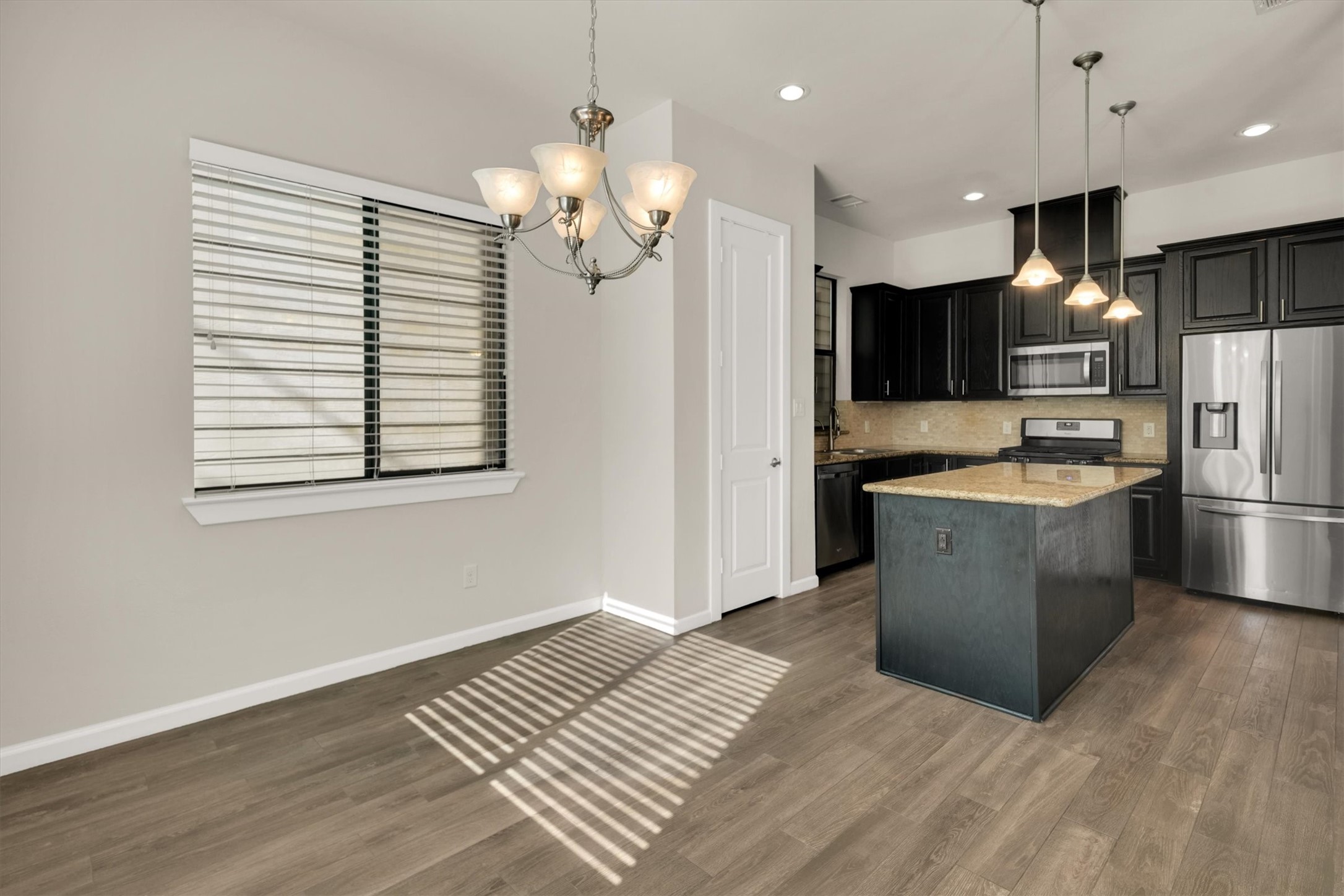 9405 Blalock Tree Court Houston, TX 77080 - Photo 11 of 39 a large kitchen with kitchen island a large counter space a sink appliances and cabinets