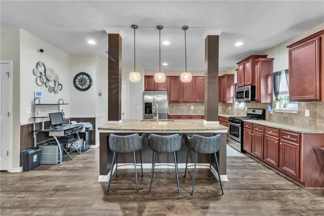 a kitchen with stainless steel appliances granite countertop wooden cabinets a stove top oven a sink and dishwasher