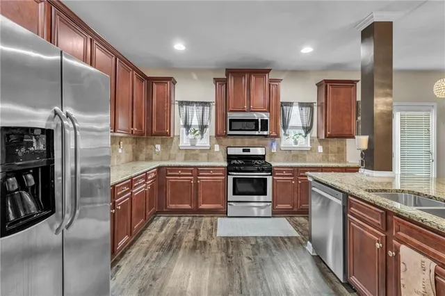 a kitchen with kitchen island granite countertop a sink a counter top and living room view