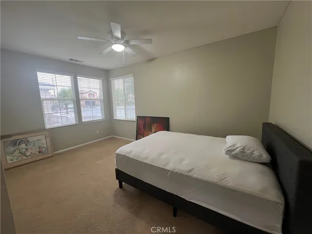 a bed sitting in a bedroom next to a window