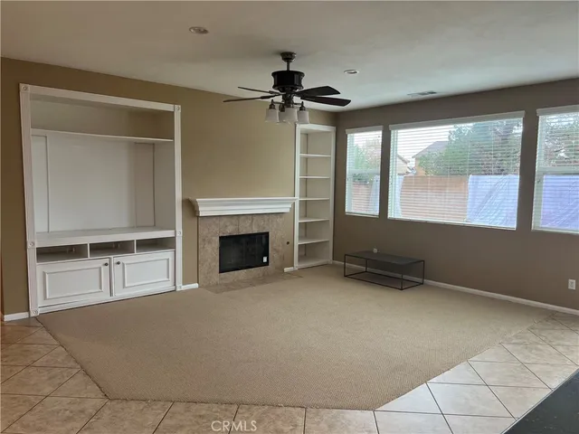 a view of an empty room with a fireplace and a window