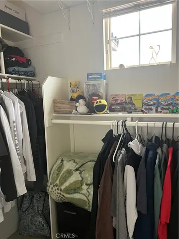 a view of walk in closet with clothes and shoes