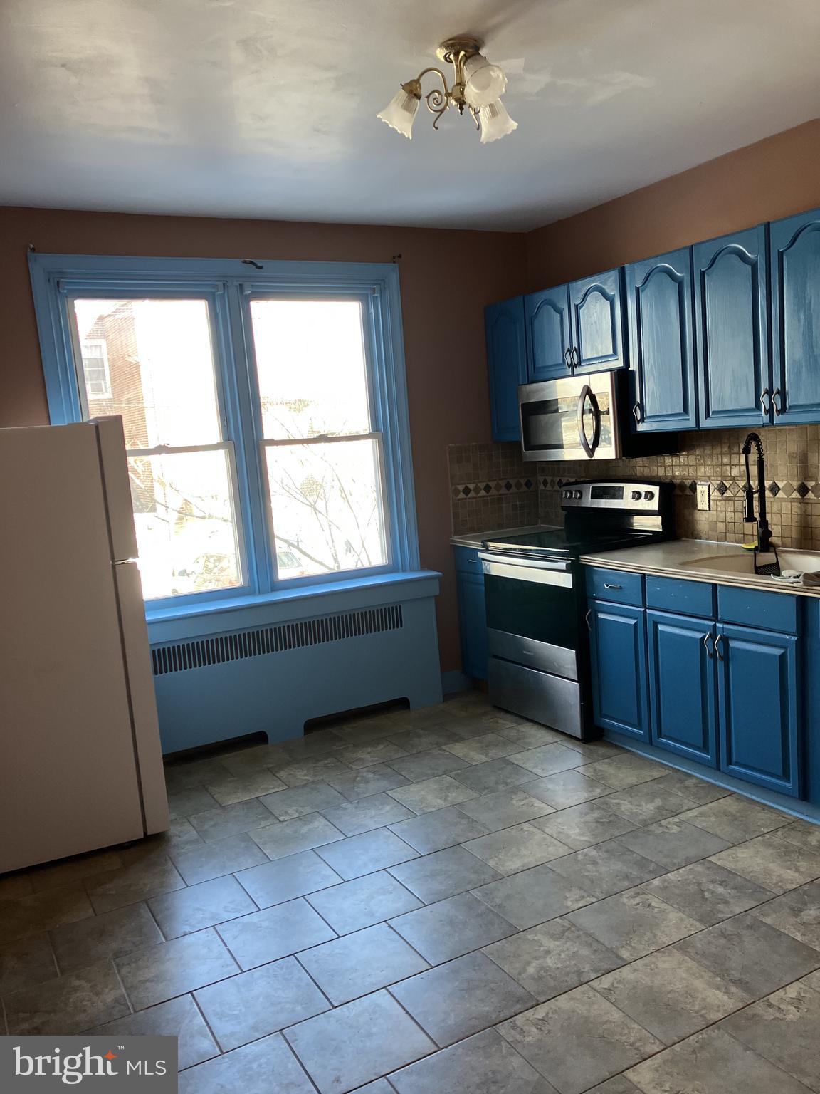 3303 Glenview Street Philadelphia, PA 19149 - Photo 4 of 7 a kitchen with granite countertop a stove sink and cabinets