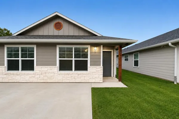 a front view of a house with a garden and yard