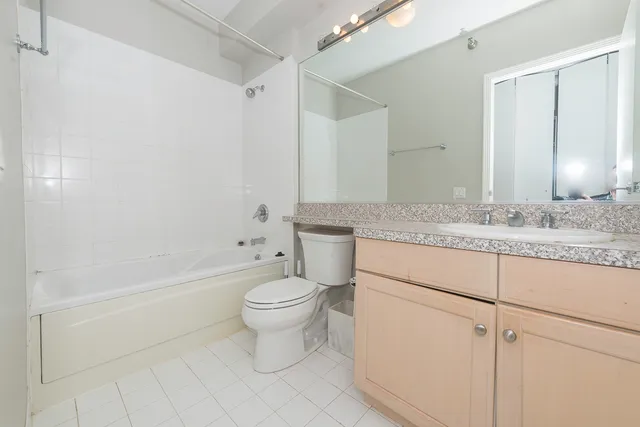 a bathroom with a granite countertop toilet a sink and a mirror