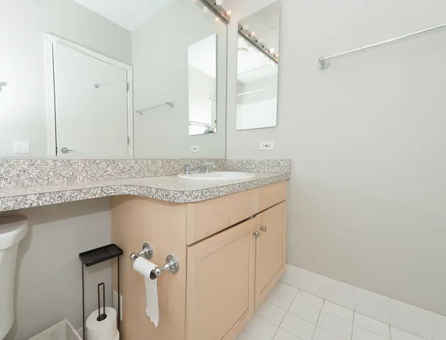 a bathroom with a granite countertop sink and a mirror