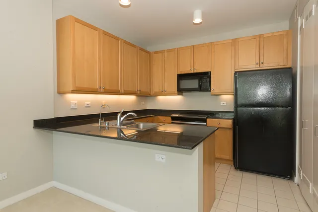 a kitchen with granite countertop a sink and a refrigerator
