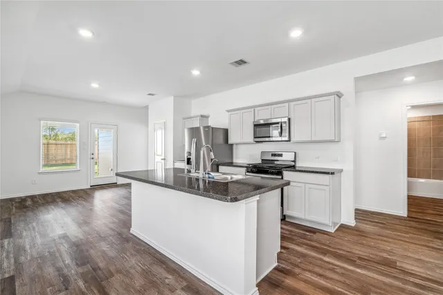 a kitchen with stainless steel appliances granite countertop a sink stove and refrigerator