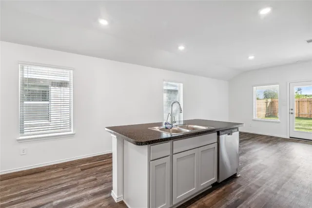 a kitchen with stainless steel appliances granite countertop a sink and wooden floor