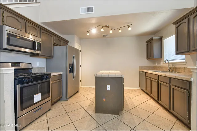 a kitchen with stainless steel appliances granite countertop a sink and a microwave